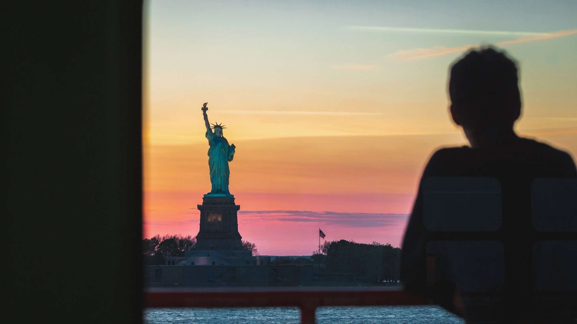 iStock-1321687931-16-9-2000x1125-min New York sunset and the Statue of Liberty